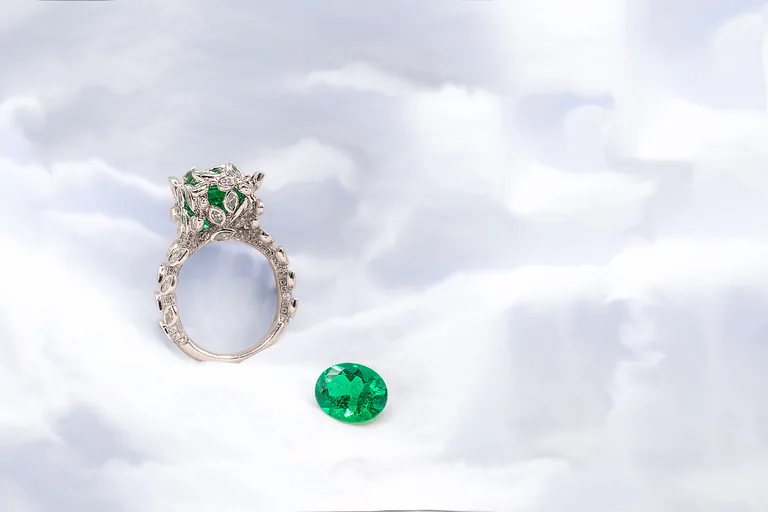 A hand-painted emerald and enamel ring design next to the finished ring
