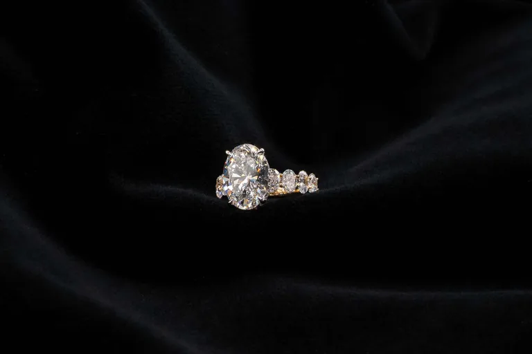 A bespoke oval diamond engagement ring in platinum on black silk